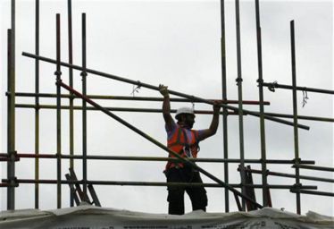 worker-takes-down-scaffolding-construction-site-london.jpg